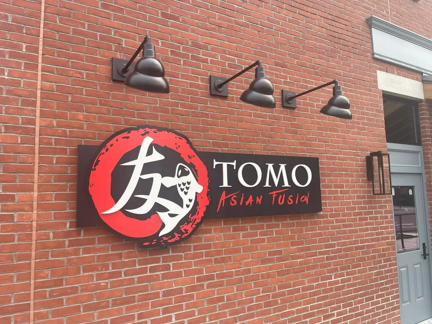 TOMO Asian Fusion sign on the brick wall outside the restaurant