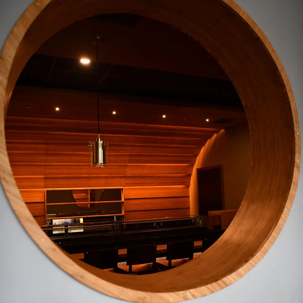 The TOMO sushi bar seen through the round bamboo window in the dining room